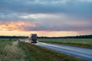 Truck driving on road on the countryside in dusk or dawn