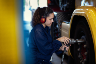 Female service technician with ear protection working with a tyre