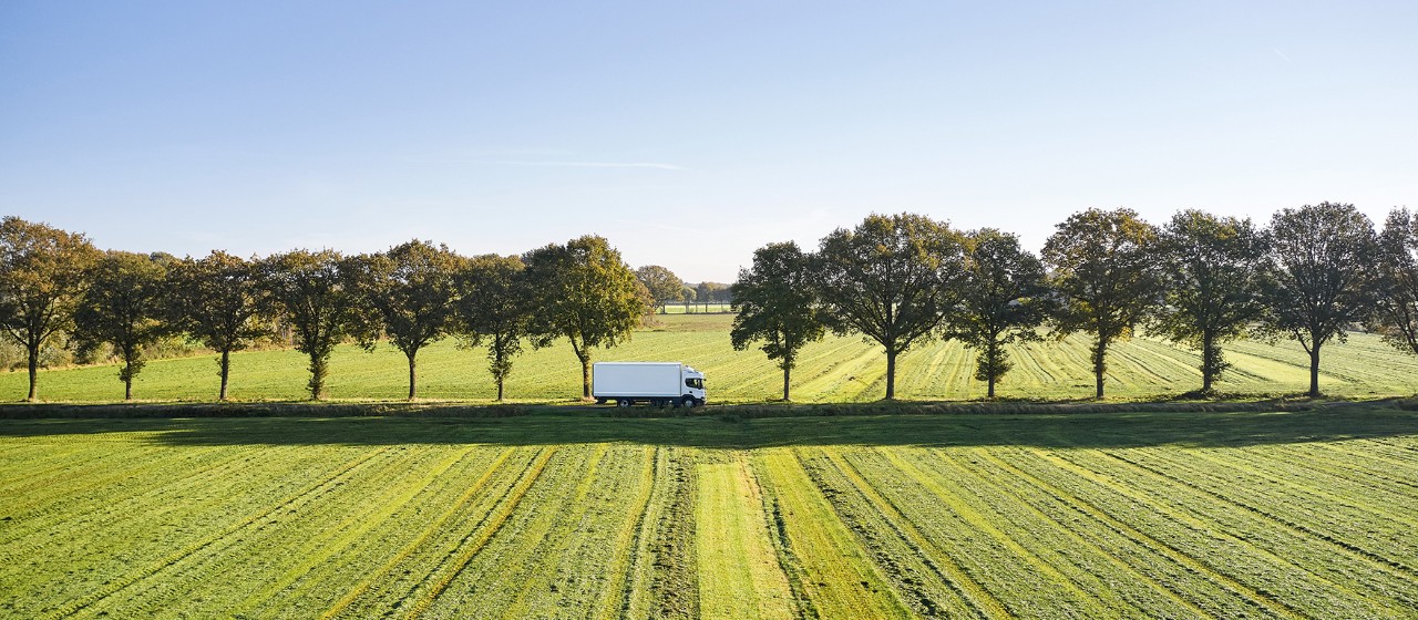 Lkw fährt in grüner Landschaft