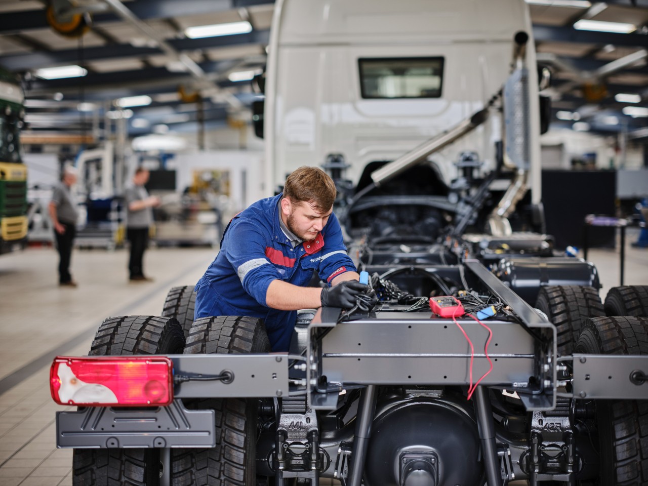 Technician working on a Scania truck in workshop