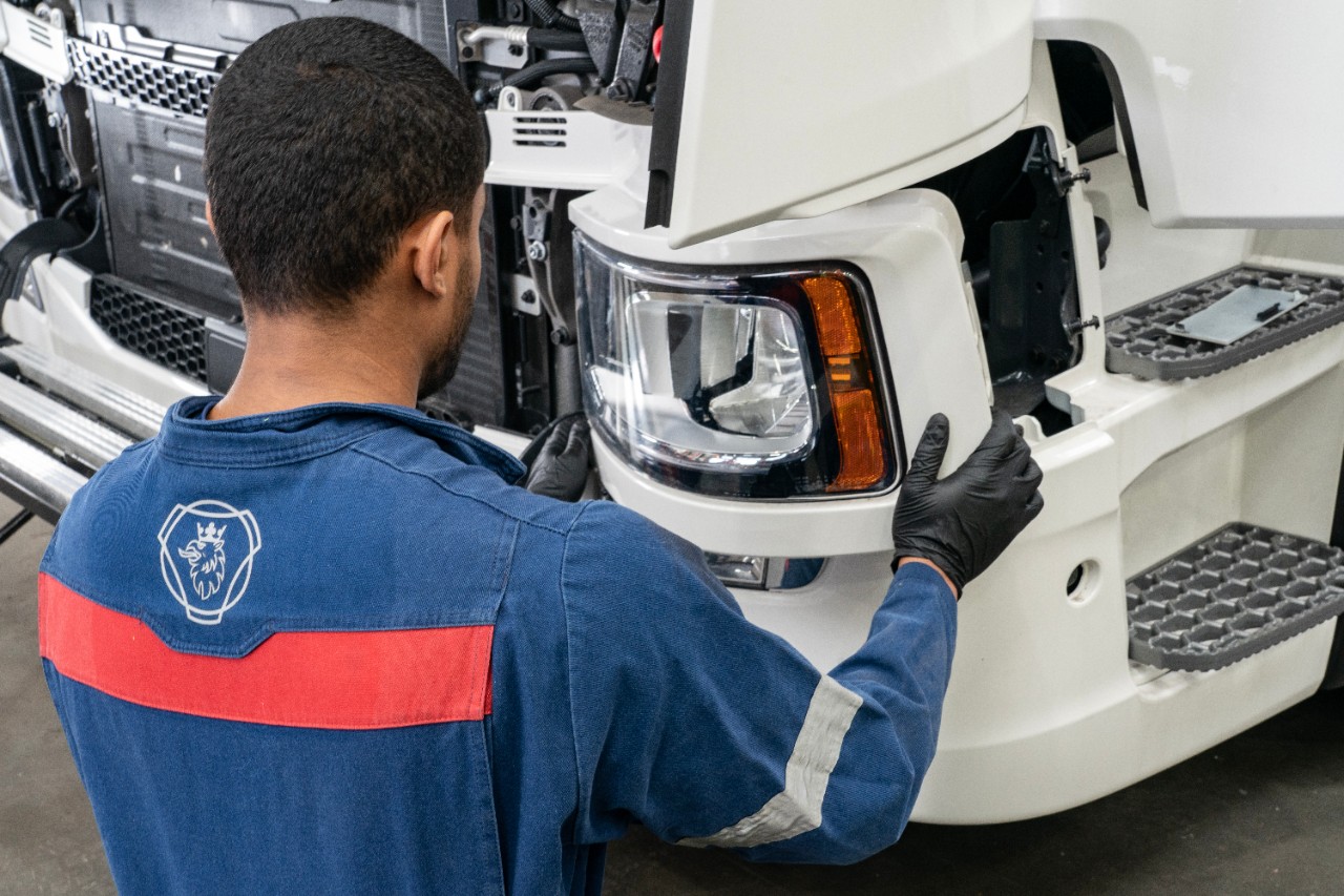 Technician working under a truck in workshop