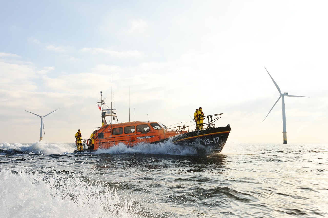 Skegness Shannon class lifeboat 13-17 Joel and April Grunhill at sea during a search and rescue exercise, wind farm in the background.