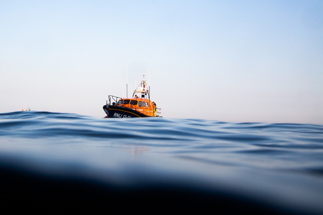 Swanage Shannon class lifeboat George Thomas Lacy 13-13 at sea shot from waterline during a training exercise with a coasteerign group off Dancing Ledge