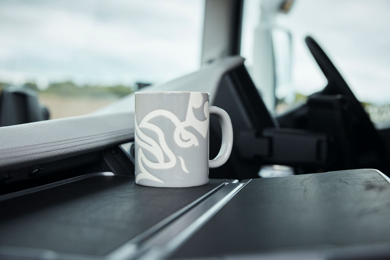 Scania branded mug on dashboard of truck