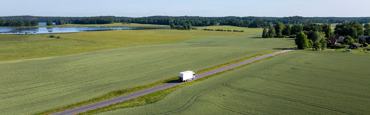 Gaslastbil som kör mellan åkrar