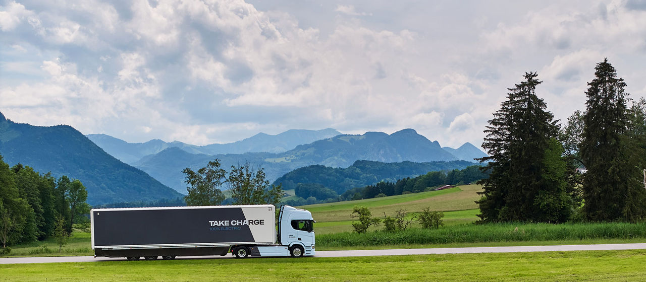 Truck driving on a road with green landscape