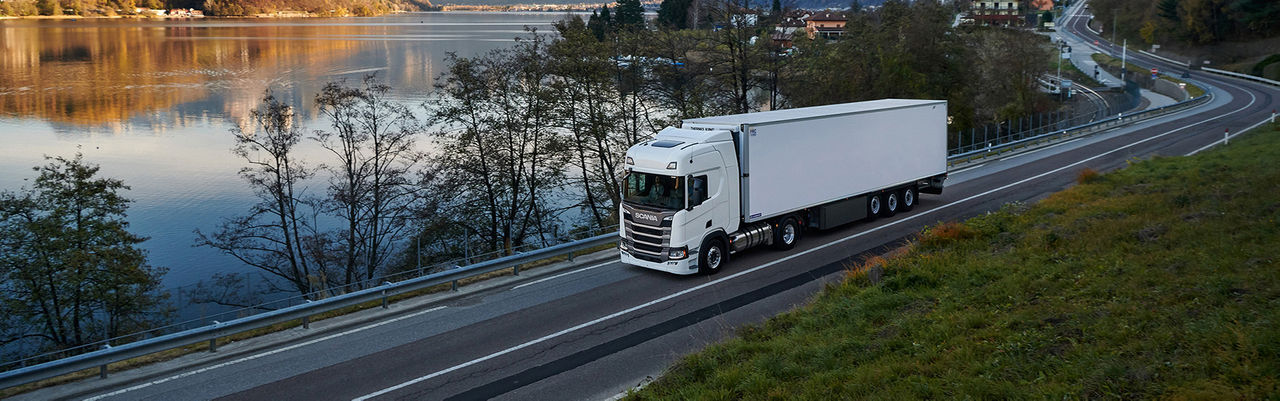 A white truck Scania R-series cruising at a small road with its best fuel efficiency