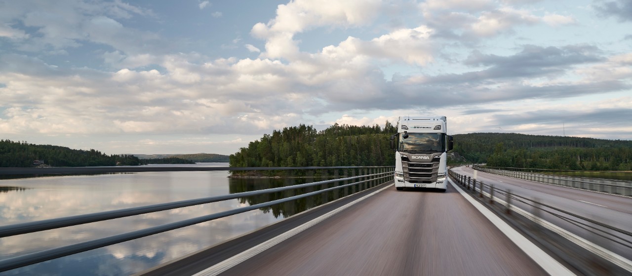 A Scania Super truck driving over a bridge